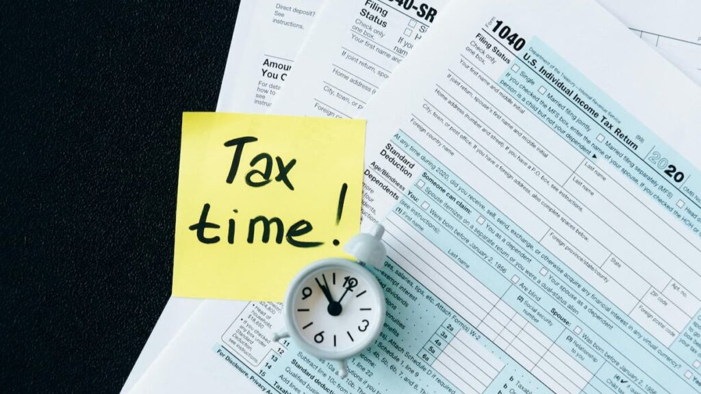책상 위에 놓인 세금 신고 서류들과 Tax Time이라고 적힌 종이, 미국 주식 양도소득세 신고 기간 알림
